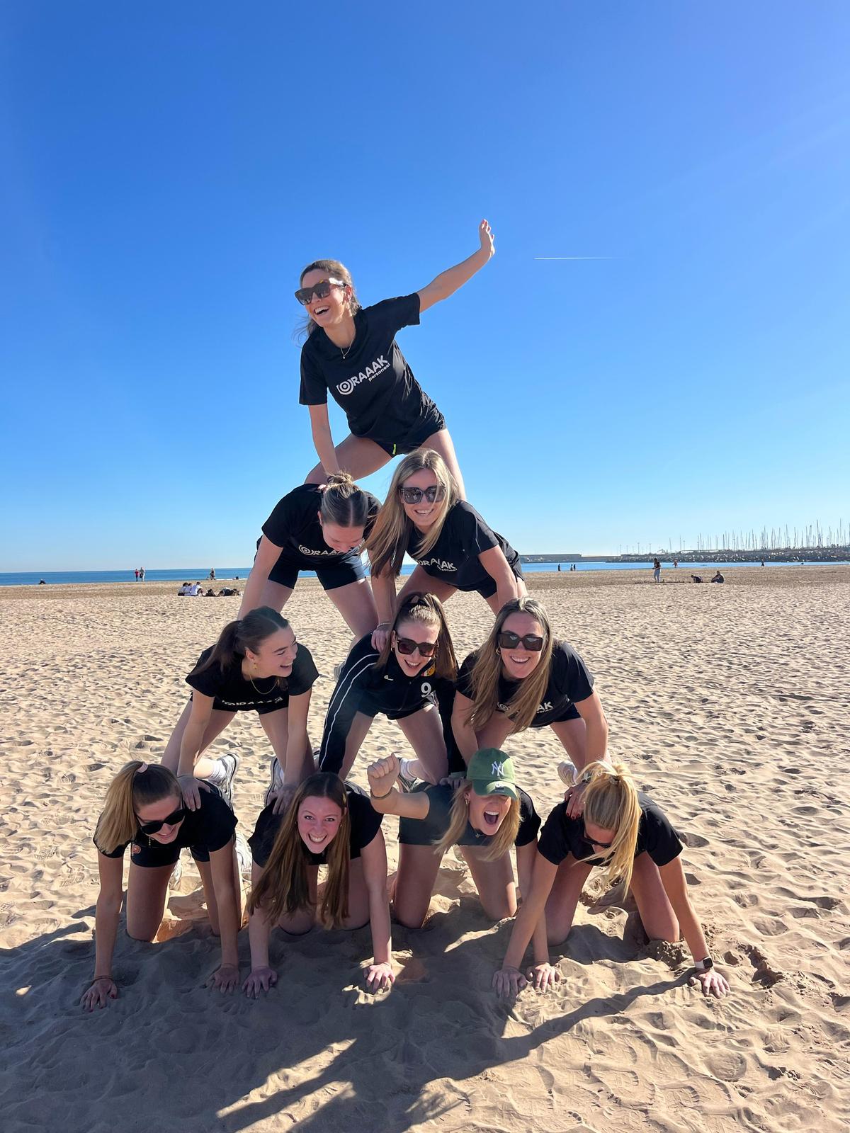 Hockeyteam maakt een piramide op het strand van Barcelona