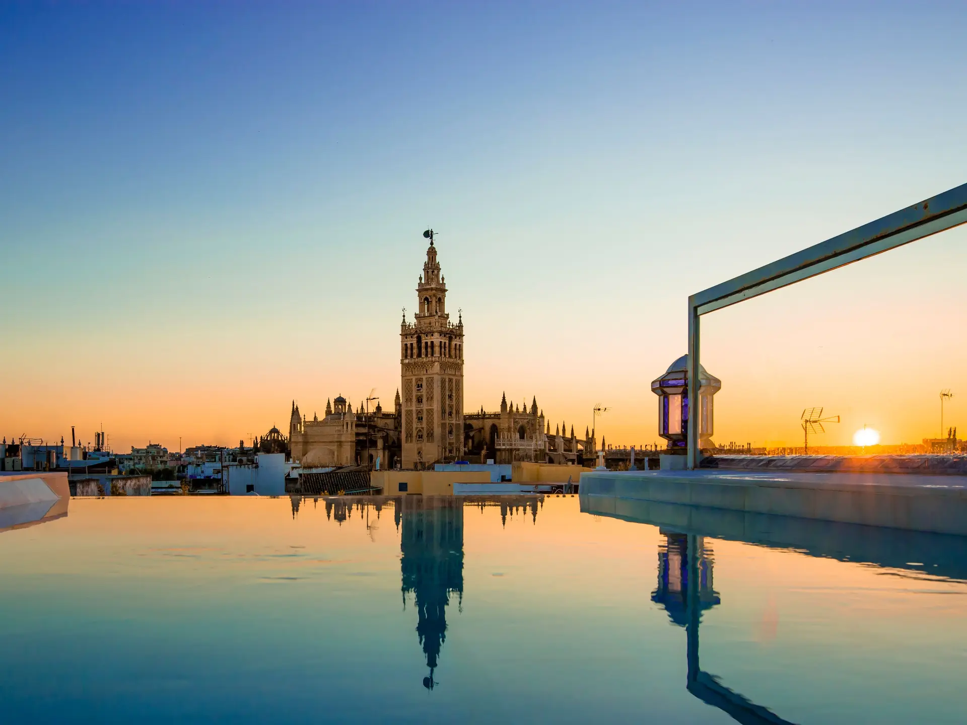 Giralda of Sevilla at sunset reflected in a rooftop pool