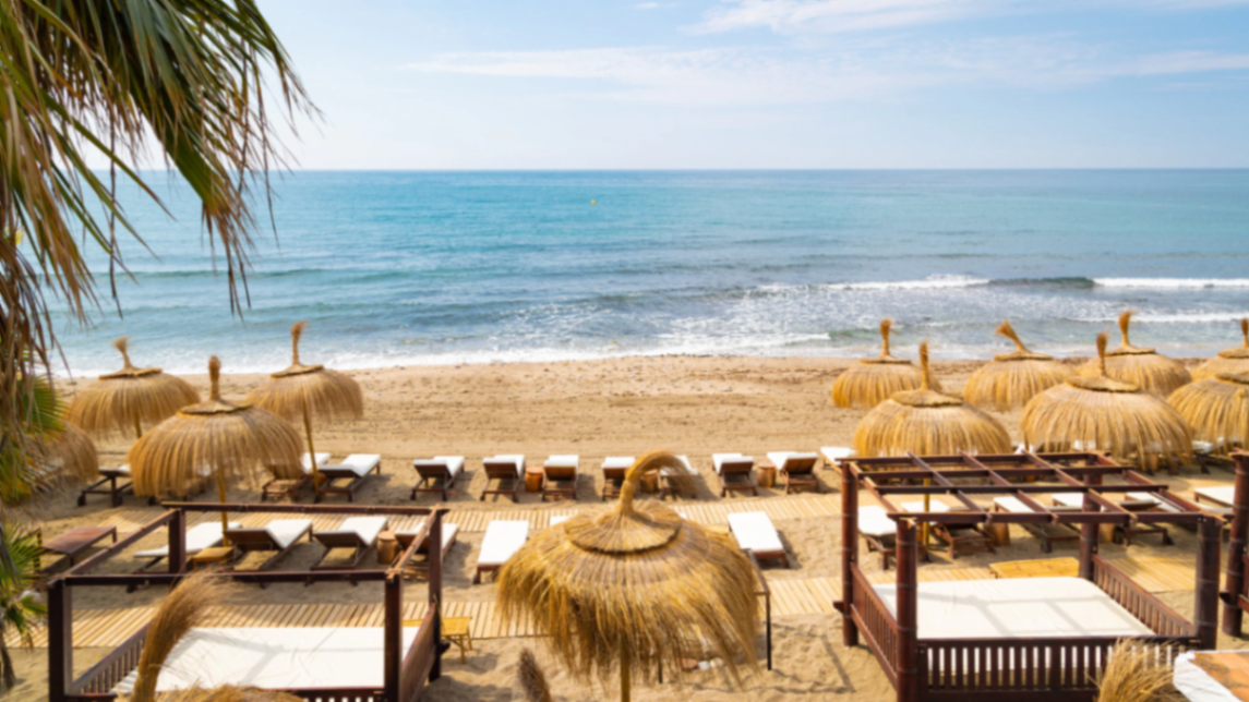 Beach club met loungebedden uitkijkend over zee in Marbella